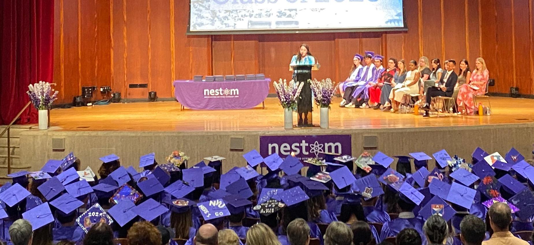 Photo of the Senior Graduation ceremony at Centennial Memorial Hall. Students sit in the audience wearing their purple gowns and caps.