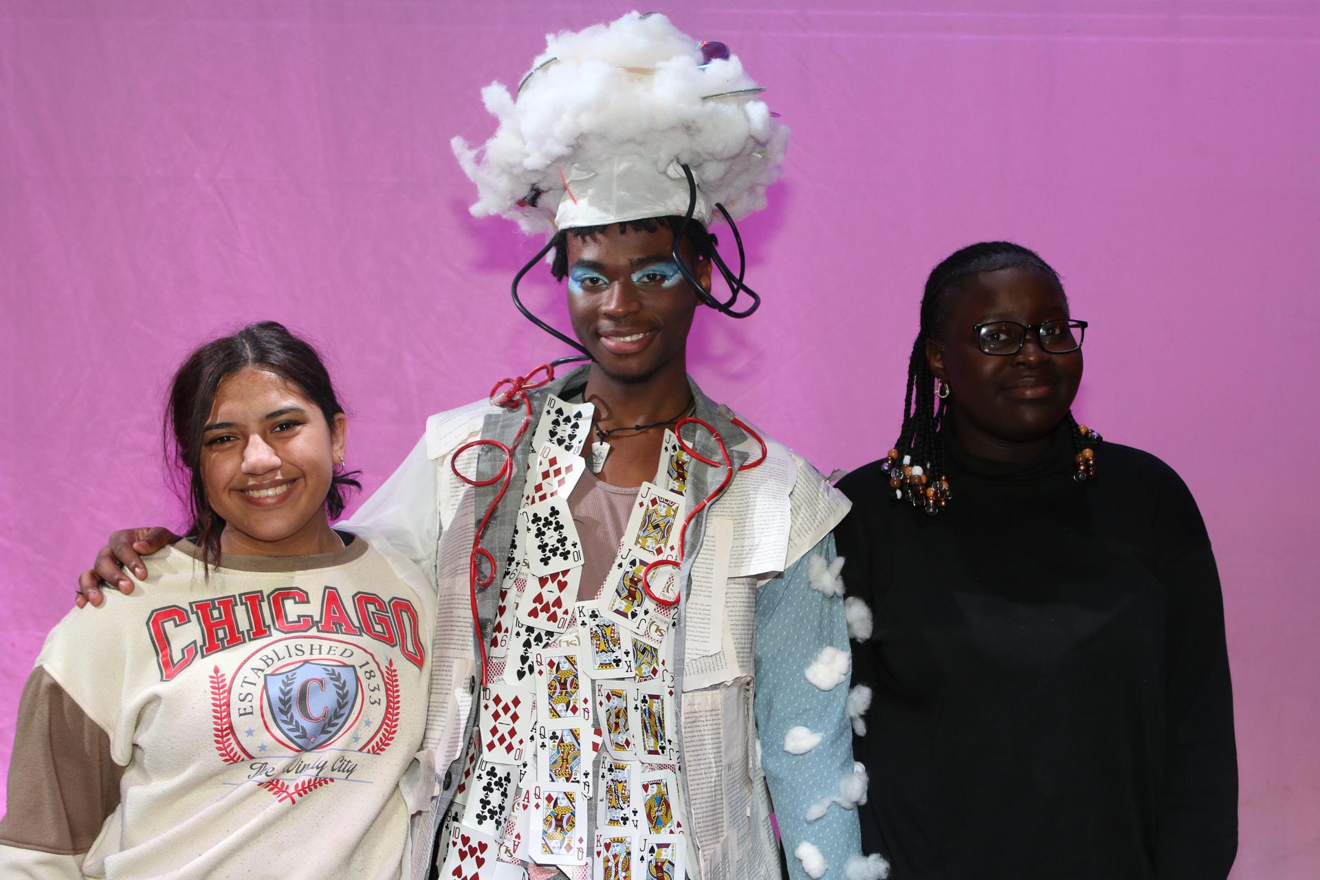 three students standing and smiling at the camera