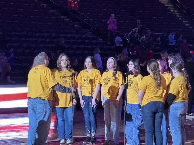 Student singing around the microphone on the court