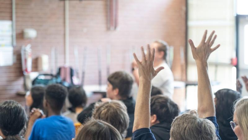 Image of audience raising hands