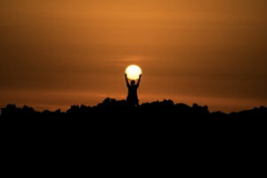 person holding the sun as it rises