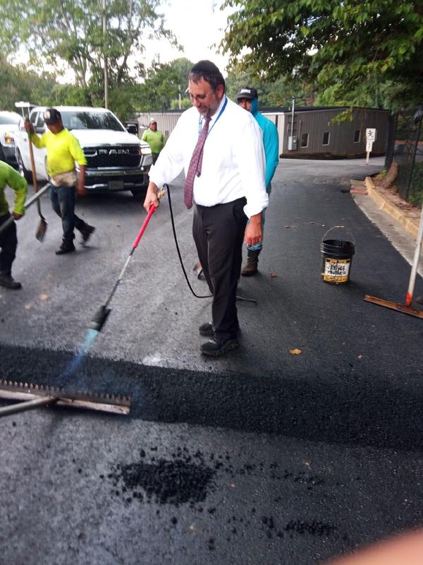 Rabbi Cohen helps prepare a speed-bump in TDSA's newly repaved lot!