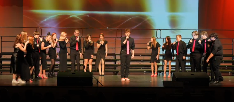 group of high schoolers singing on stage