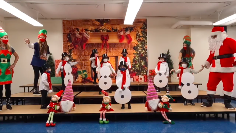 Students in snowman outfits dancing on stage