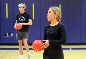 a boy and girl each holding a red ball