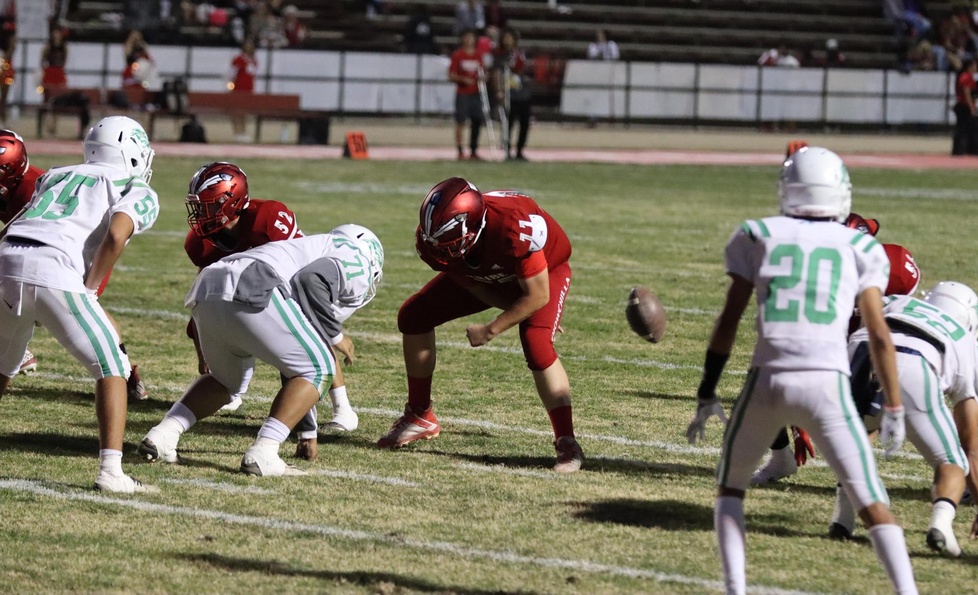varsity football players in action against Riverdale
