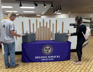 Two students sliding voter registration forms into the box.