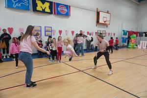 Two teachers swing a rope for students to jump.