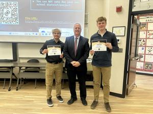 Camden and Liam holding certificates beside superintendent Dr. Foley