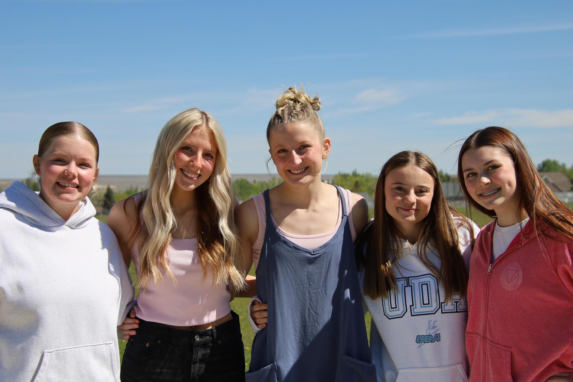 five high school girls standing outside and smiling for group photo