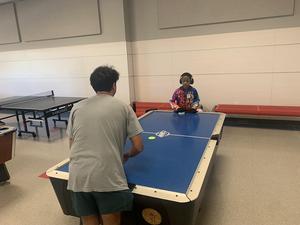 A mentor plays air hockey with his mentee