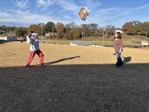 Students hitting pinata in the air