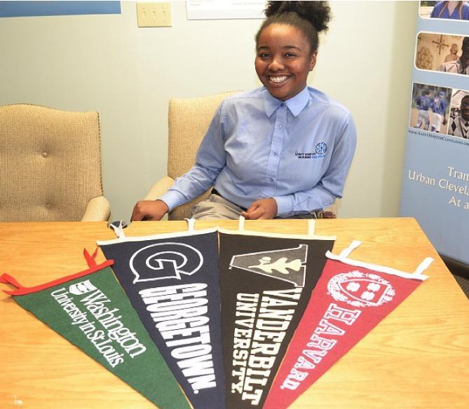 Girl sitting with college banners at table