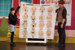 Two people hold up a sign showing different emotions.