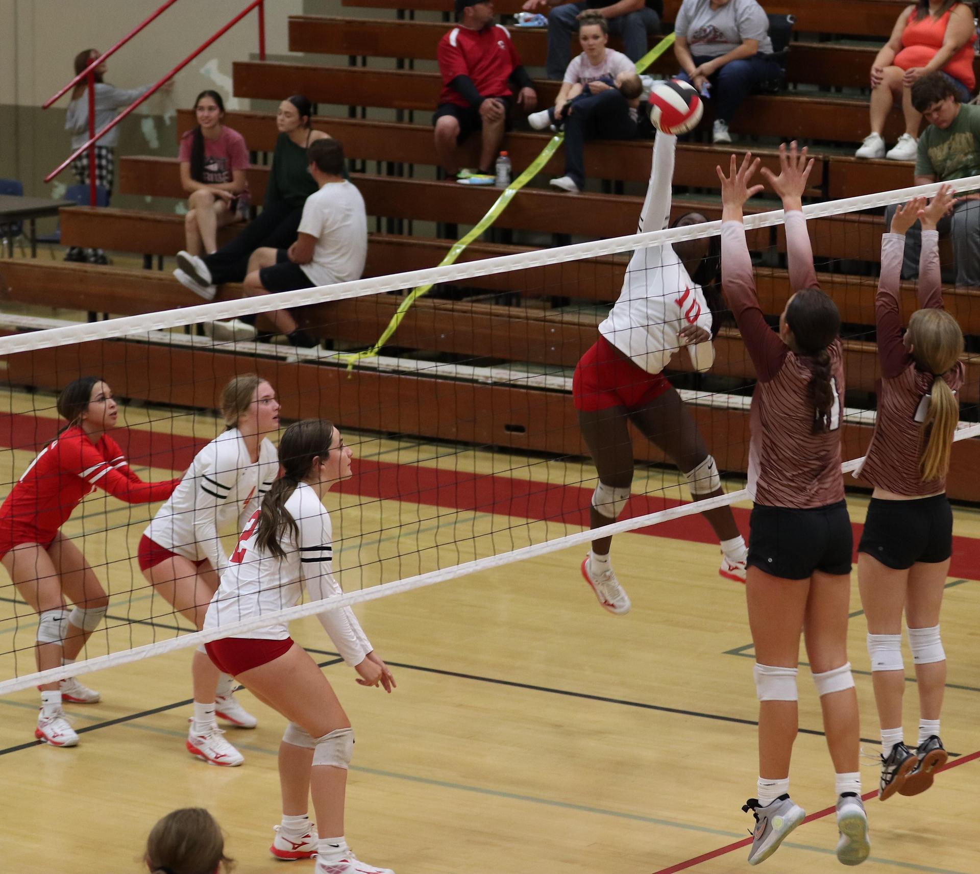varsity volleyball players in action against Fresno Christian