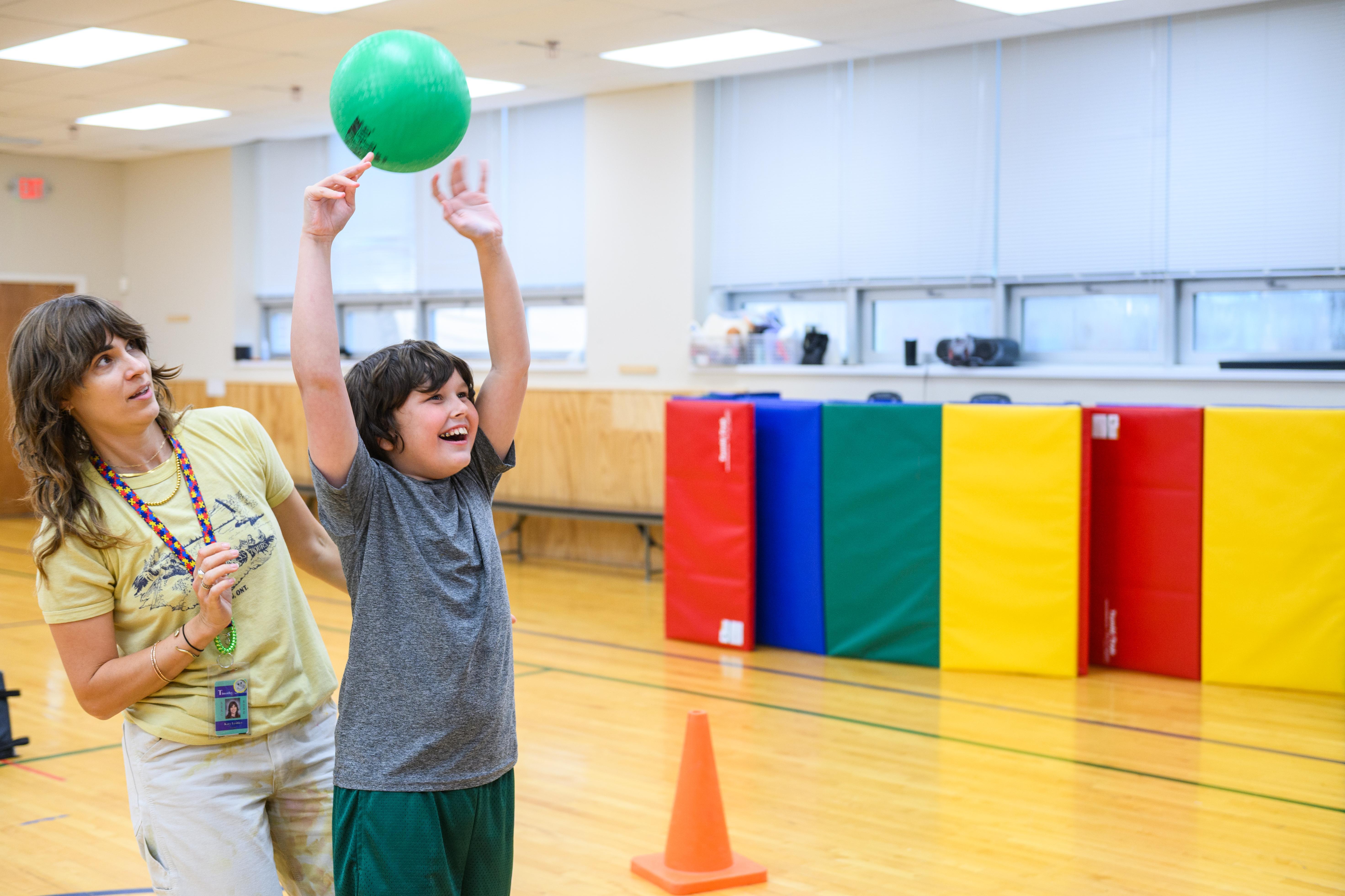happy teacher playing ball with student