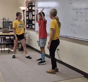 Students act out scenes using the meaning of a word