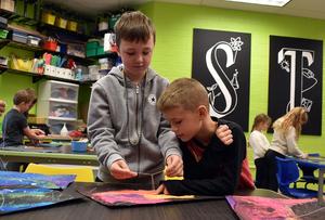 two boys tying a piece of string