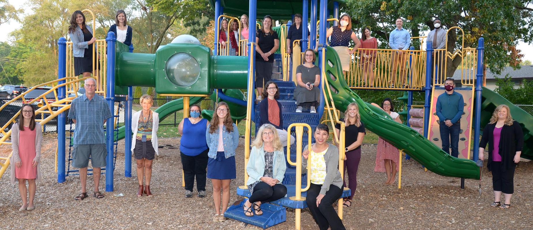 photo of staff standing on playground equipment 6 feet apart