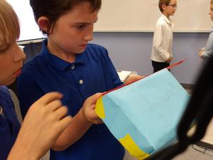 Two boys measure their box.