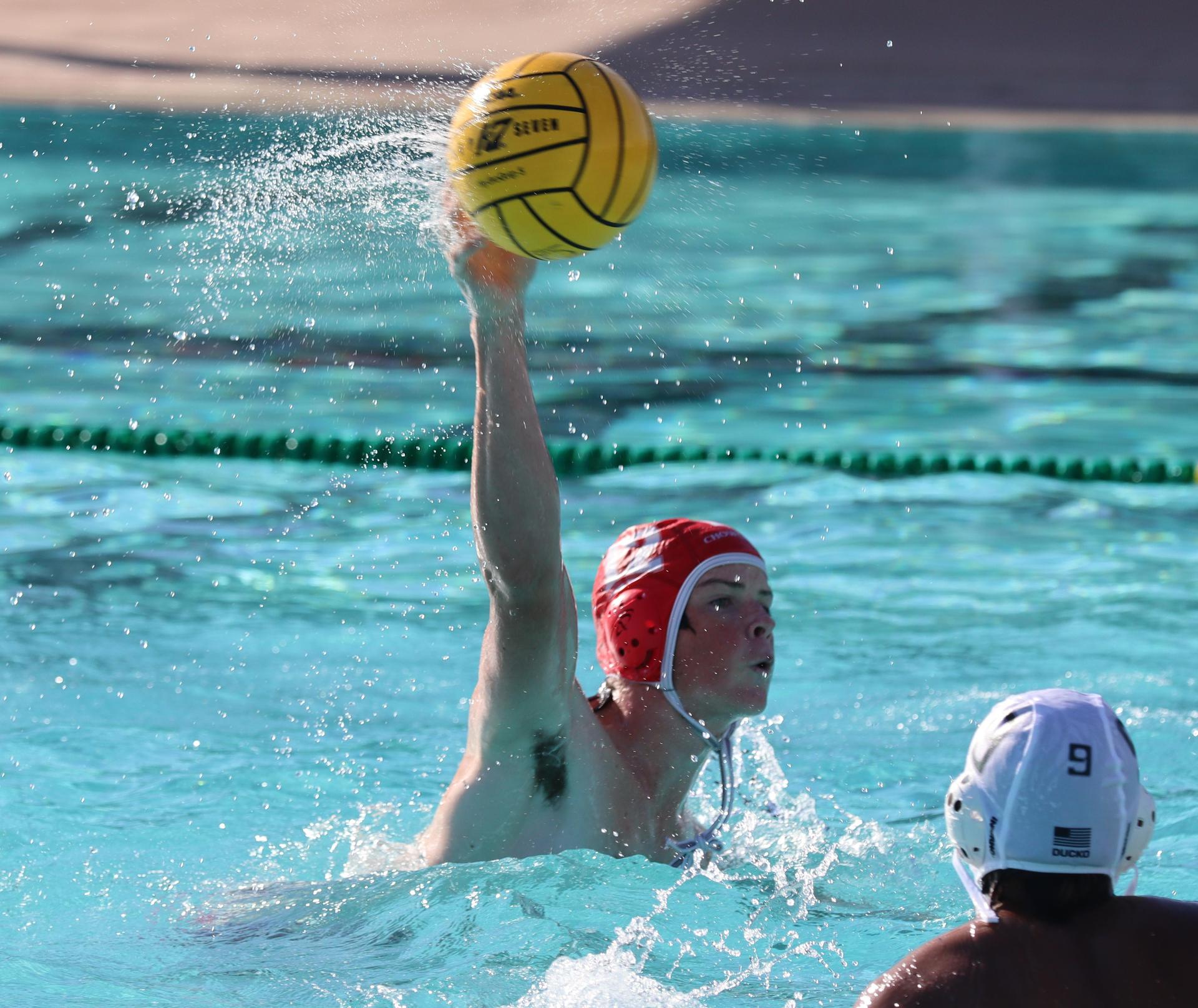 boys water polo players in action against hoover