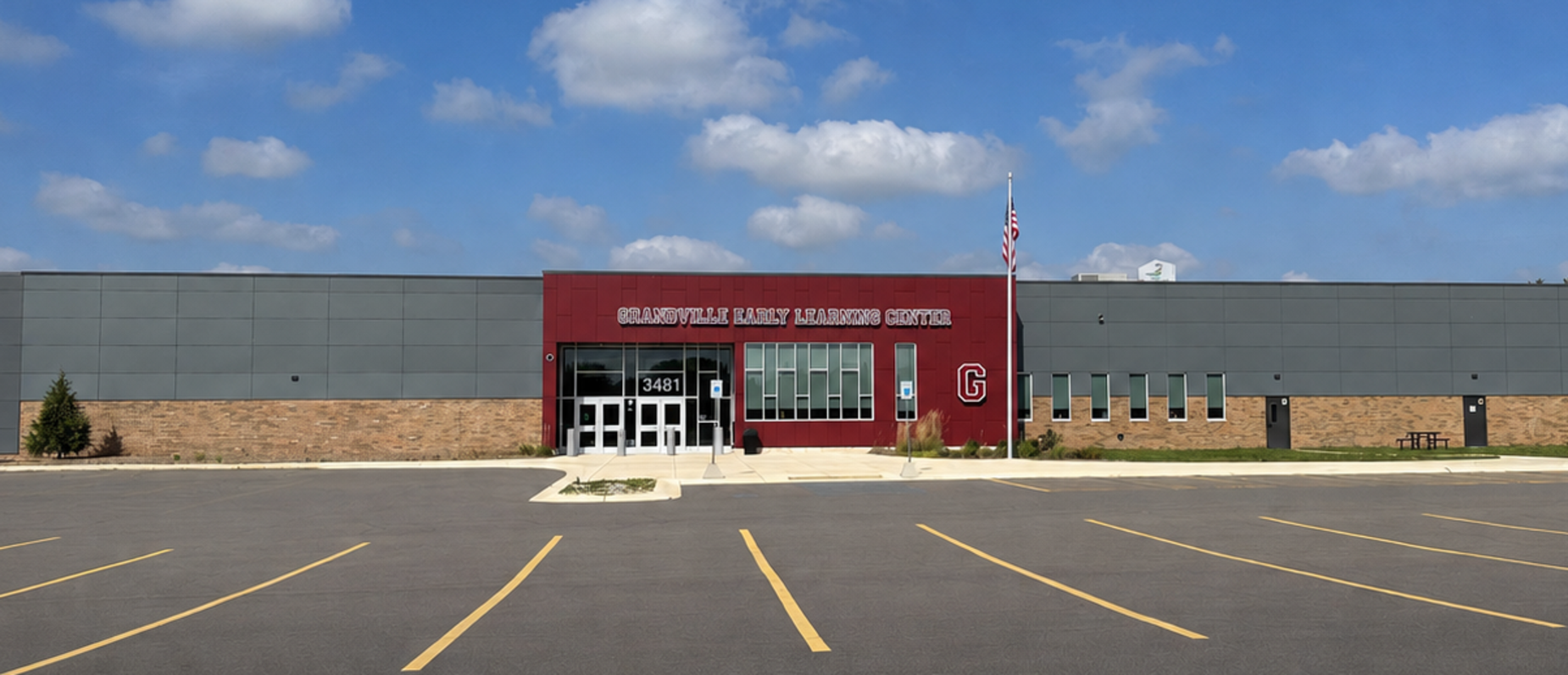 Grandville Early Learning Center exterior on a sunny day with a maroon main entrance