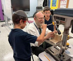 Rabbi Rubin supervises a student as they build an Esrog Box