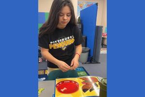 8th-grader Gianna Acker practices number identification by feeding the dog the correct number of bones