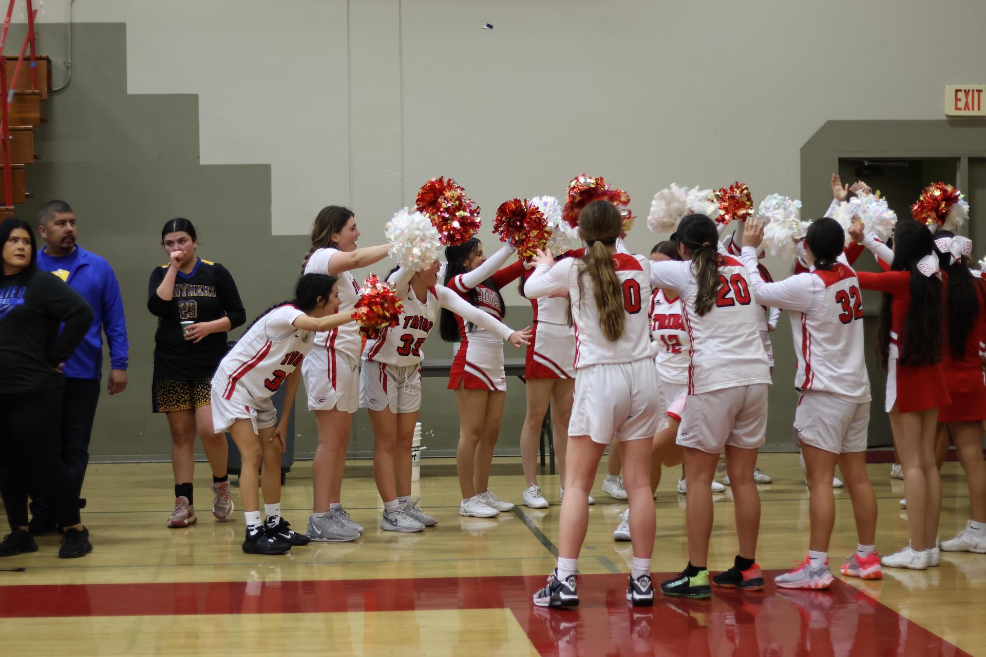 varsity girls basketball players running onto the court