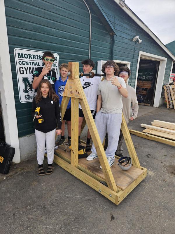 MCS students pose on a trebuchet they built