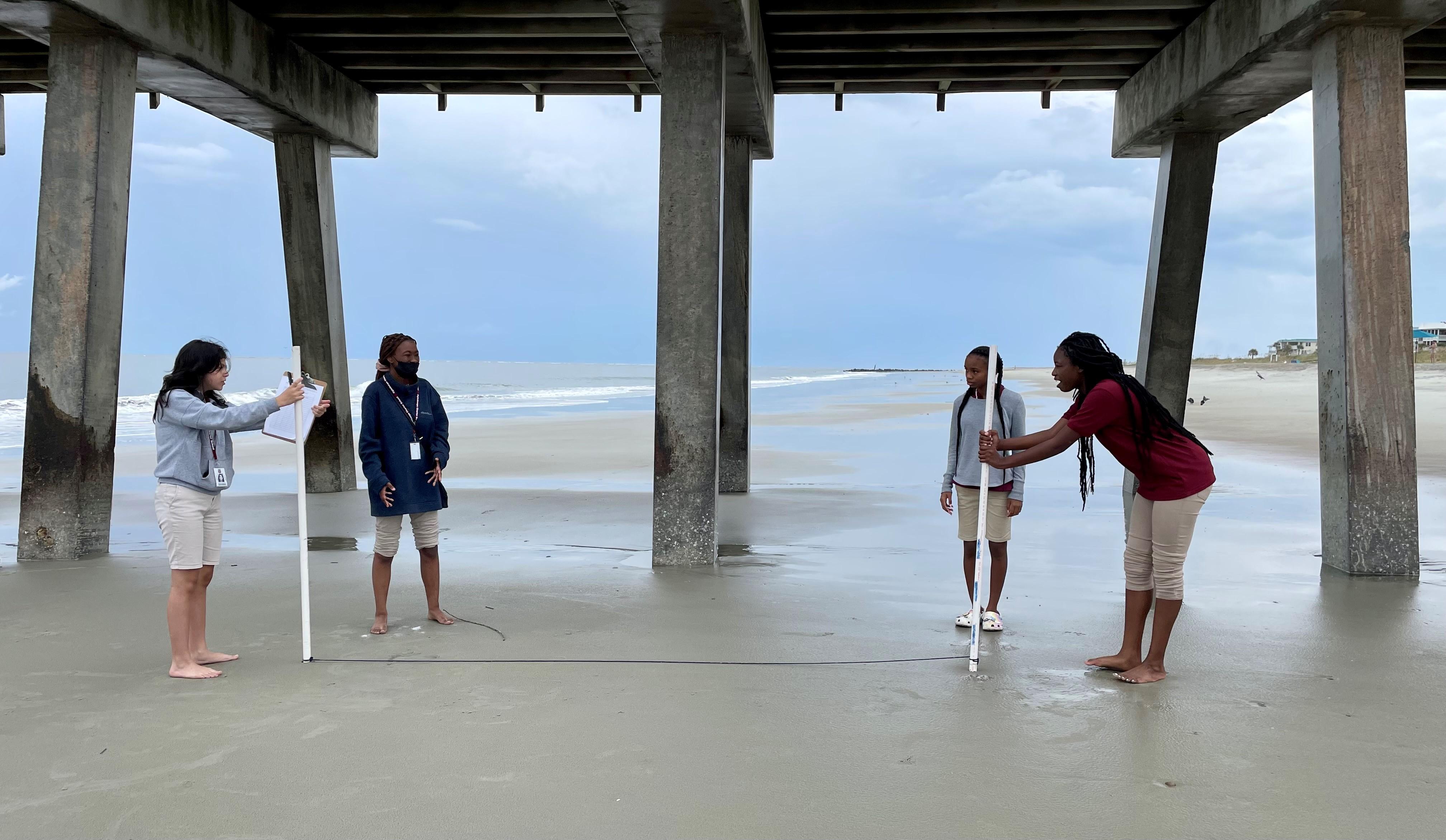 Marine Science students under bridge on beach