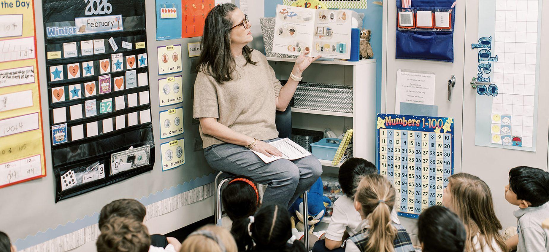 Coppell Classical Academy kindergartners sit on the rug while their teacher reads to them