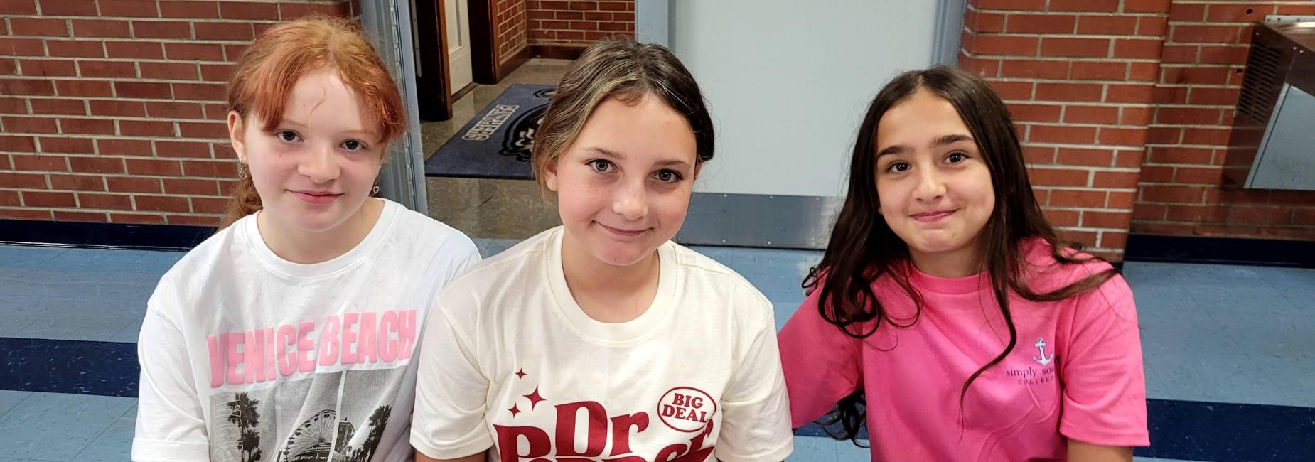Three students sitting at a table in the cafeteria