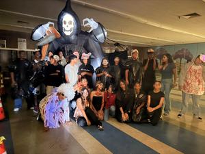 Costumed students pose by a giant grim reaper at the Cochran haunted house