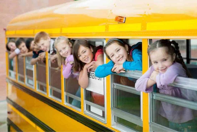 kids sticking their heads out of the bus windows