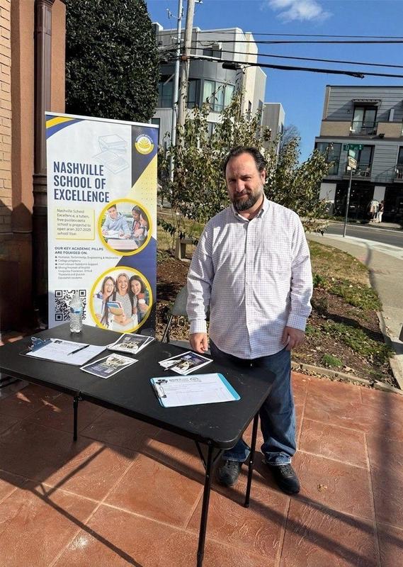 Nashville School of Excellence volunteer collecting parent interest forms during a community outreach event.