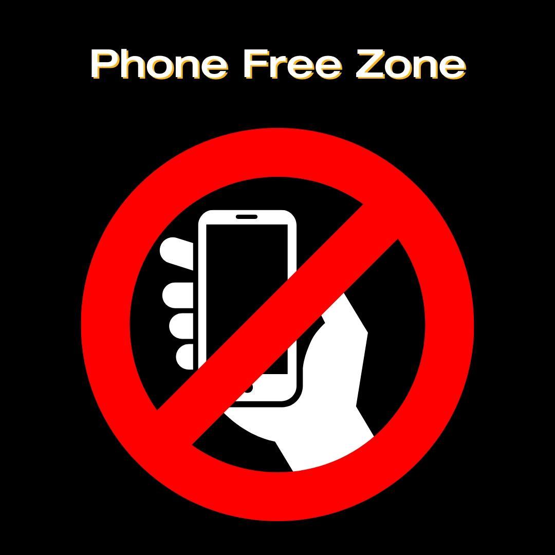 Image states: "Phone Free Zone" with an icon of a phone in a hand with the red prohibited circle over it.