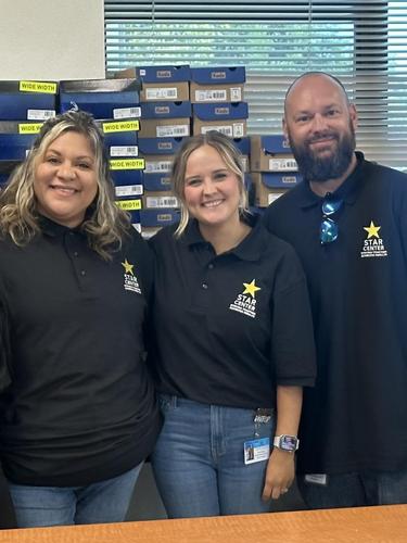 Four individuals standing together, smiling in matching polo shirts.