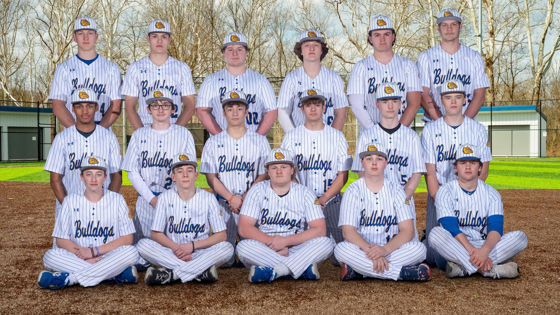 Group of high school baseball players in striped uniforms posing outdoors.