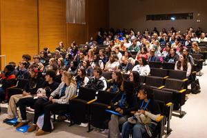 Students listen to instructions in a small auditorium