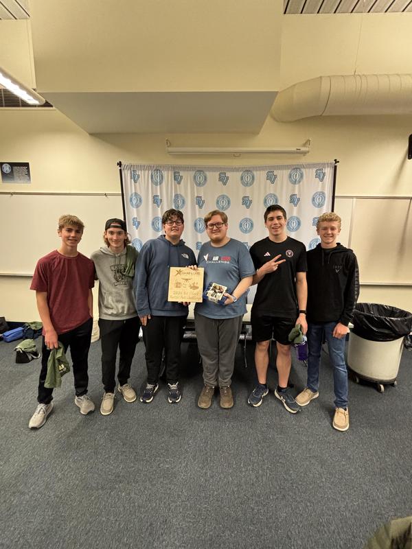 six boys smiling at camera holding 1st place plaque and their battle bot