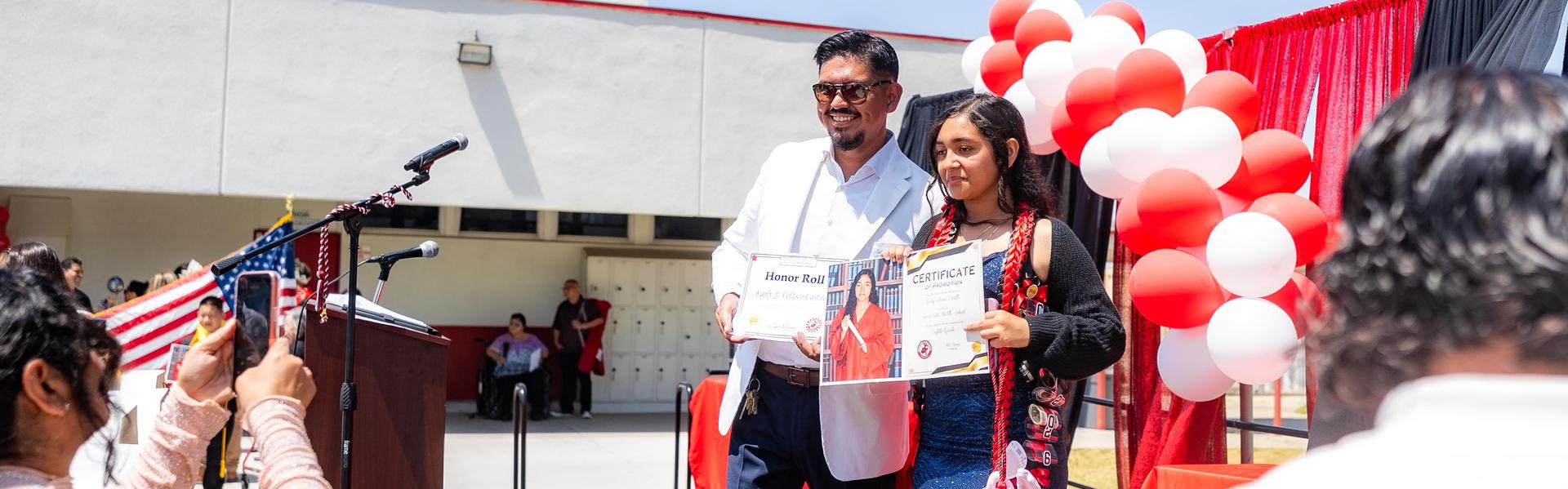 School Principal and student posing for a parents picture.