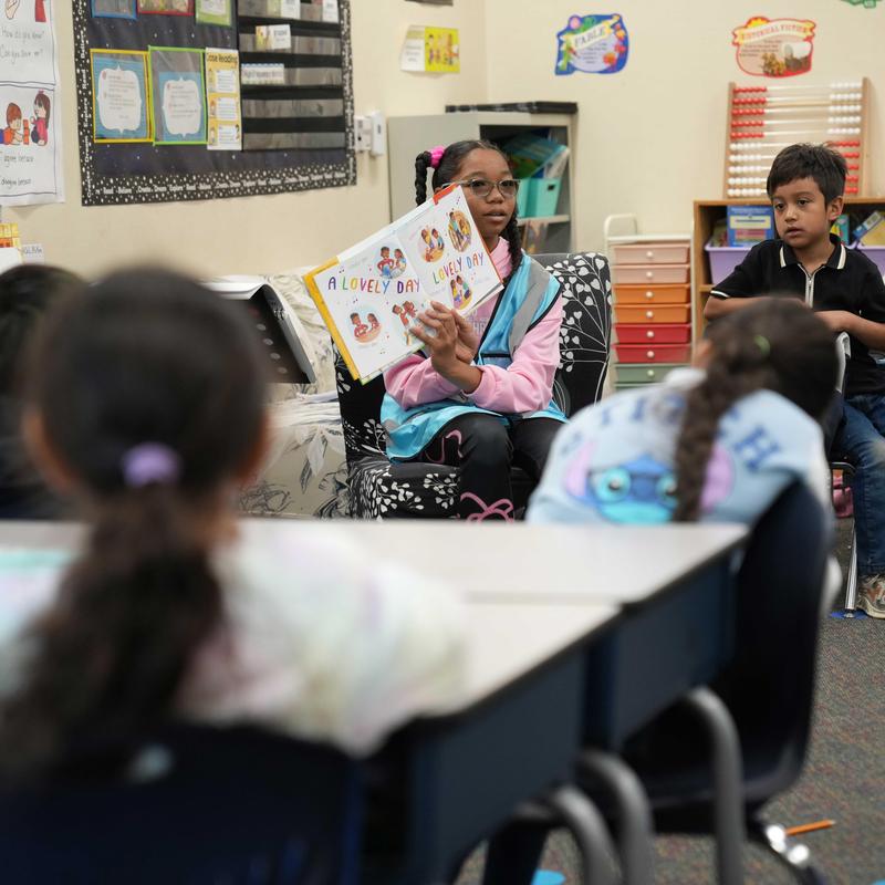 Student reading to a class