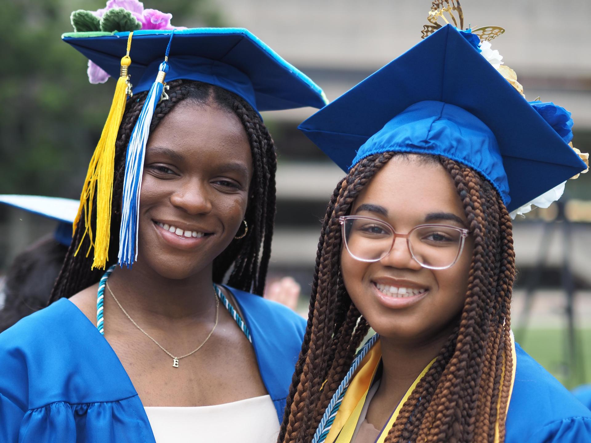 Two senior graduates in cap and gown