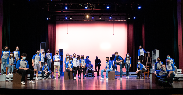 group of teens on stage in matching shirts