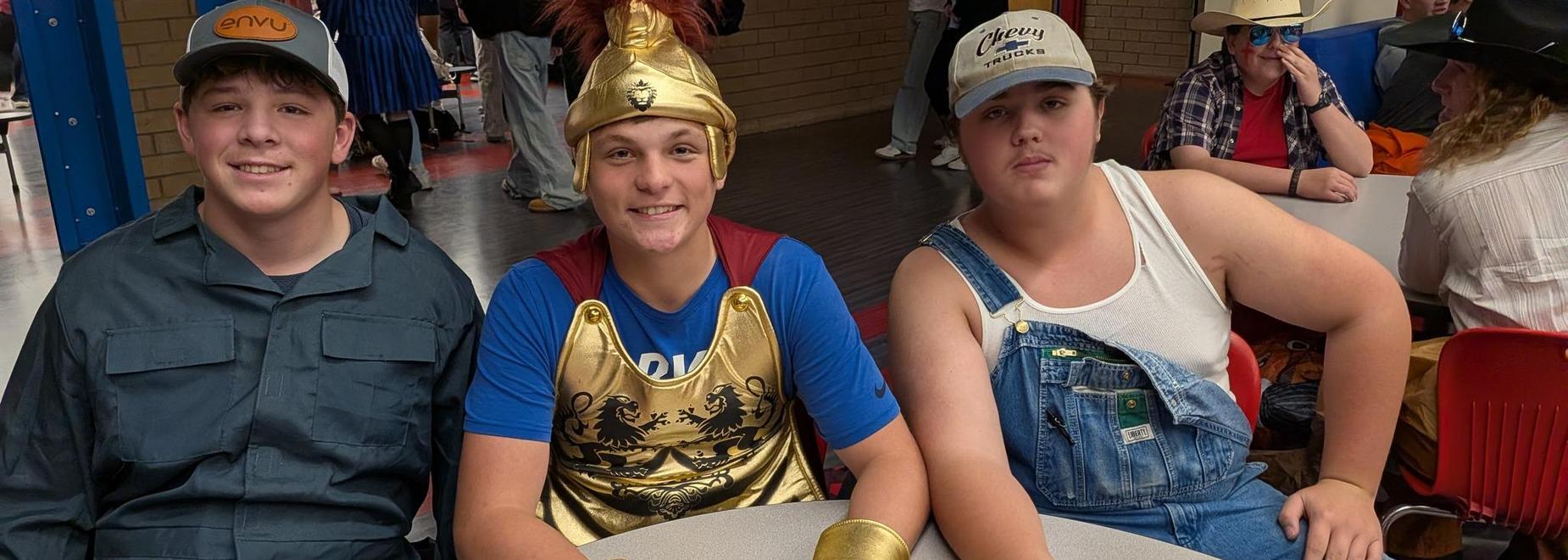 Three teens in costumes posing together at an event.