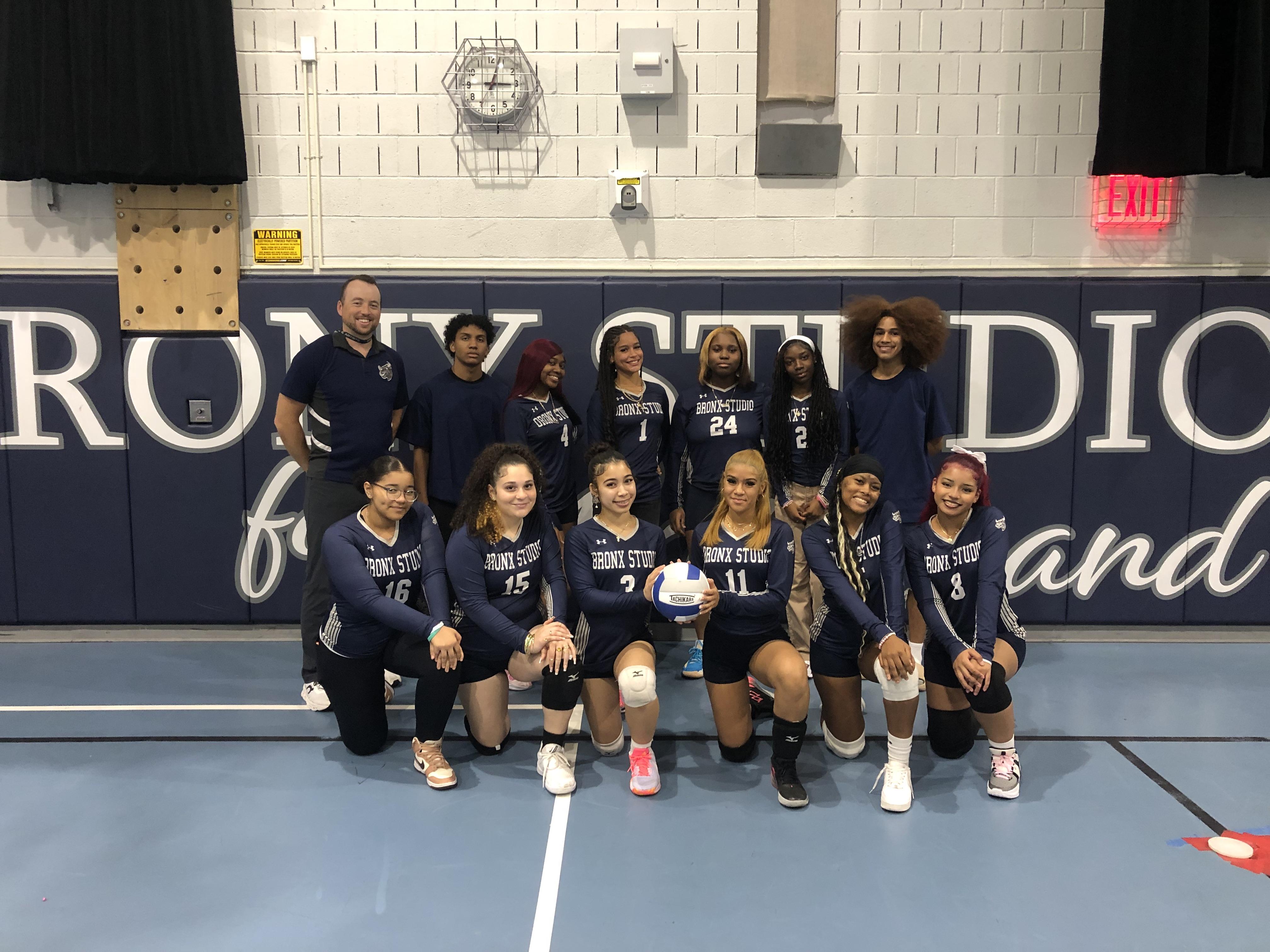 Girls volleyball team posing for photo with coach