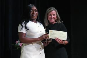 Telitita Burley accepts the award and check from Dr. Rhodes