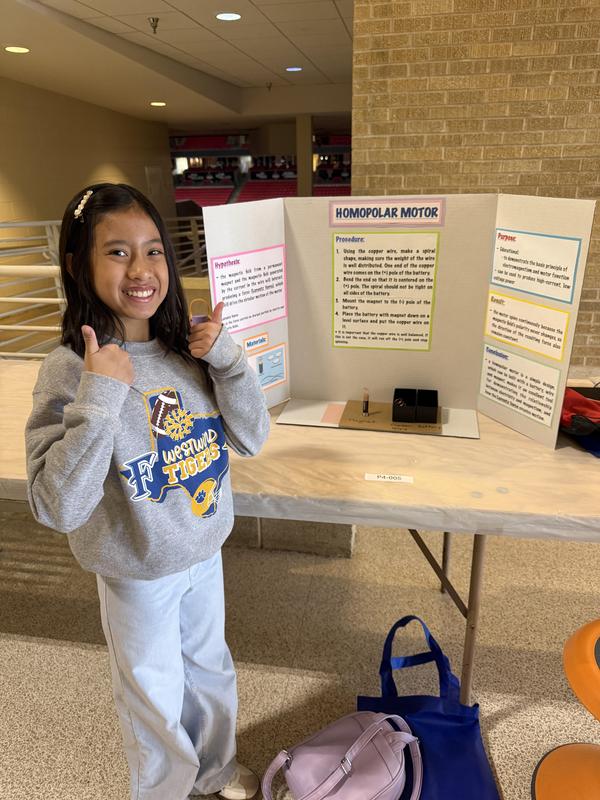 Westwind student posing with her science fair project at the regional fair
