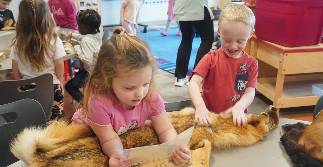 Students feel an animal pelt that helps keep animals warm in winter.